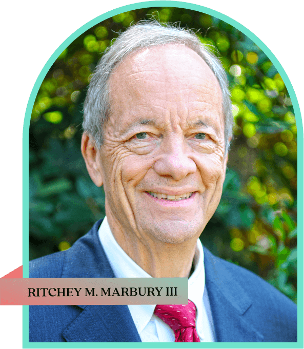 Portrait of an elderly man smiling outdoors with greenery in the background.