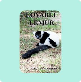 A black and white lemur lying on grass with the text 'Lovable Lemur'.